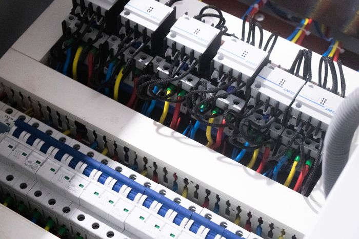 Zwei Dachdecker auf einem Hausdach mit Holzlattung und teilweise verlegten Solarmodulen, Gerüst und Lieferwagen.